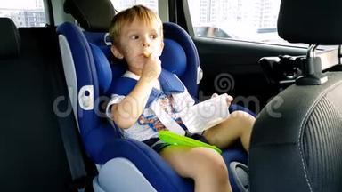 3岁幼儿男孩坐在儿童车安全座椅上吃东西的4镜头
